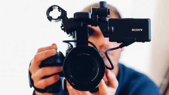 Man holding camera while filming